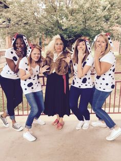 a group of women standing next to each other wearing dalmatian shirts and hats