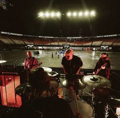 some people are playing drums in an empty stadium