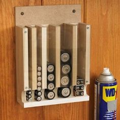 a wall mounted battery holder next to a can of spray paint