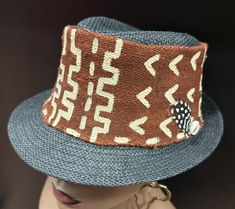 A classy brown and black Mudcloth  and straw hat combination. It has  hand painted bold african art designs . This can be made to fit . It is a unisex hat that both men and women will enjoy. The hat has endless possibilities .  For more selections visit the hat and scarf section at evelyncreationinc@etsy.com. Don't delay order yours today. Brown Woven Fedora Straw Hat, Brown Woven Brimmed Panama Hat, Brown Woven Fedora Sun Hat, Brown Woven Fedora With Short Brim, Brown Woven Straw Hat With Flat Brim, Brown Woven Brimmed Fedora, Adjustable Brown Woven Fedora, Brown Woven Straw Bucket Hat, Black Handwoven Brimmed Hat