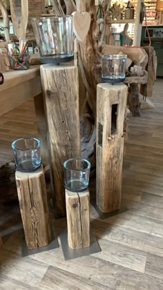 three glass vases and two wooden candlesticks are on display in a store