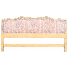 a wooden headboard with pink flowers on it