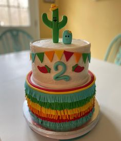 a birthday cake with two candles on top and decorations around the edges, sitting on a table