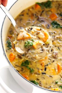 a ladle full of mushroom soup with carrots and broccoli