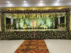 a decorated stage set up with flowers and greenery for a wedding or other function