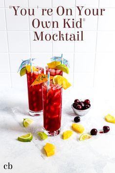 two glasses filled with red liquid and garnished with lemons, cherries and lime wedges