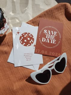 some cards and sunglasses are sitting on a table with an orange cloth next to them