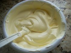 a white bowl filled with cream on top of a counter