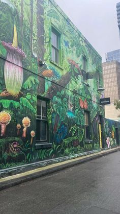 a large mural on the side of a building with flowers and plants painted on it