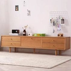 a wooden dresser sitting on top of a white rug