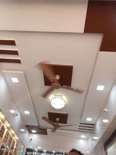 a man standing under a ceiling fan in a room