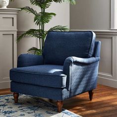 a blue chair sitting on top of a wooden floor next to a potted plant