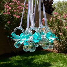 a chandelier hanging from the ceiling in a yard with pink flowers behind it