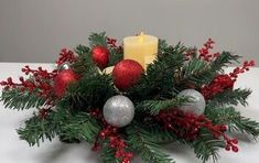 a christmas centerpiece with candles and ornaments