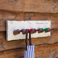 an umbrella is hanging on the wall with two hooks and a striped tote bag