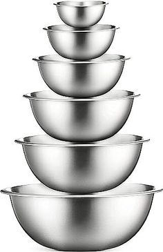 five stainless steel bowls stacked on top of each other in front of a white background