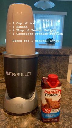 a blender sitting on top of a counter next to a bottle of nut butter