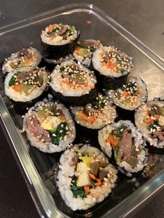 there are many sushi rolls in the plastic container