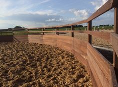 a wooden fence in the middle of a dirt field