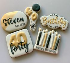 four decorated birthday cookies with candles and balloons in the shape of letters, numbers, and words