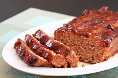 meatloaf on a white plate with slices cut off and ready to be eaten