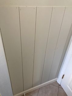 the corner of a room with a door and tile floor