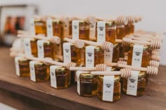 honey jars with labels on them sitting on a wooden table in front of other items