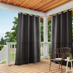 an outdoor deck with black curtains on it