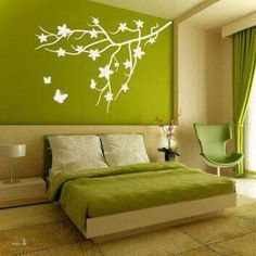 a bedroom with green walls and white flowers on the wall