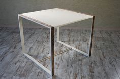 a small white table sitting on top of a hard wood floor