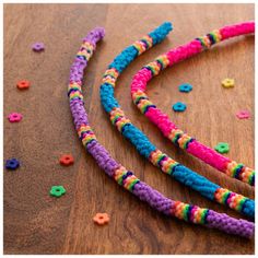 three different colored beads on a wooden surface with confetti sprinkles