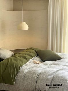 a bed with green pillows and a white headboard next to a window in a bedroom