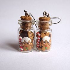 two glass jars filled with cookies and candy canes on top of a white surface