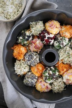 a pan filled with different types of food on top of a table next to a bowl