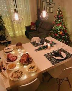 a dining room table is set for christmas dinner with food and candles on the table