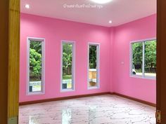 an empty room with pink walls and windows