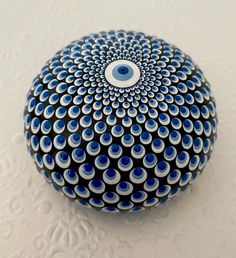 a blue and white object with an eye on it's center is sitting on a table