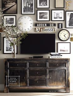 there is a tv and many pictures on the wall in this living room with a plant