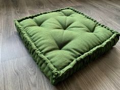 a green square cushion on the floor