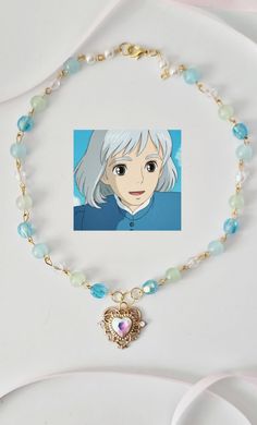 an anime character with white hair and blue eyes is shown on a beaded necklace