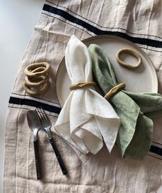 a plate with napkins and silverware on top of it next to a fork