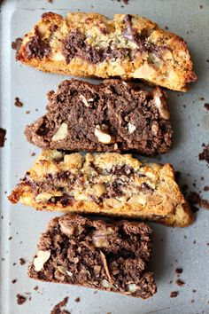 four pieces of chocolate and almond bread on a baking sheet with one cut in half