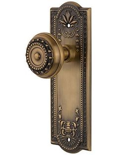 an ornate door handle with a keyhole and knob on the front of a door