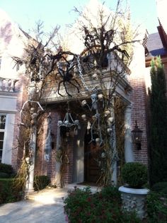 a house decorated for halloween with fake skeletons and spider webs hanging from the roof