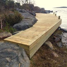 a wooden dock sitting on top of a rocky shore