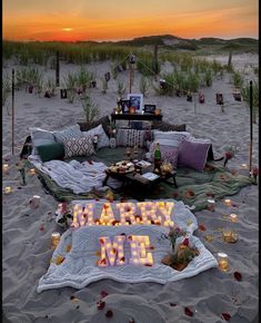 a beach scene with candles and decorations on the sand at sunset, including a sign that says happy new year