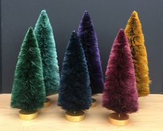 four different colored trees are sitting on a table