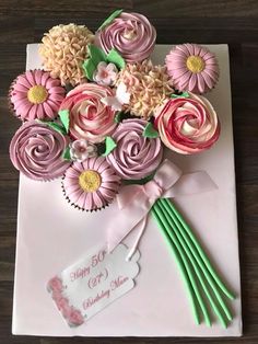 a bouquet of pink flowers on top of a white envelope with a happy 50th card