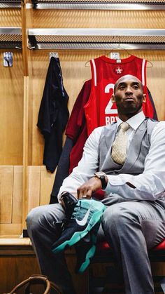 a man sitting in a locker room wearing a suit and tie