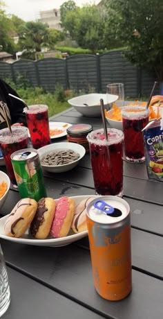 an outdoor table with drinks and food on it